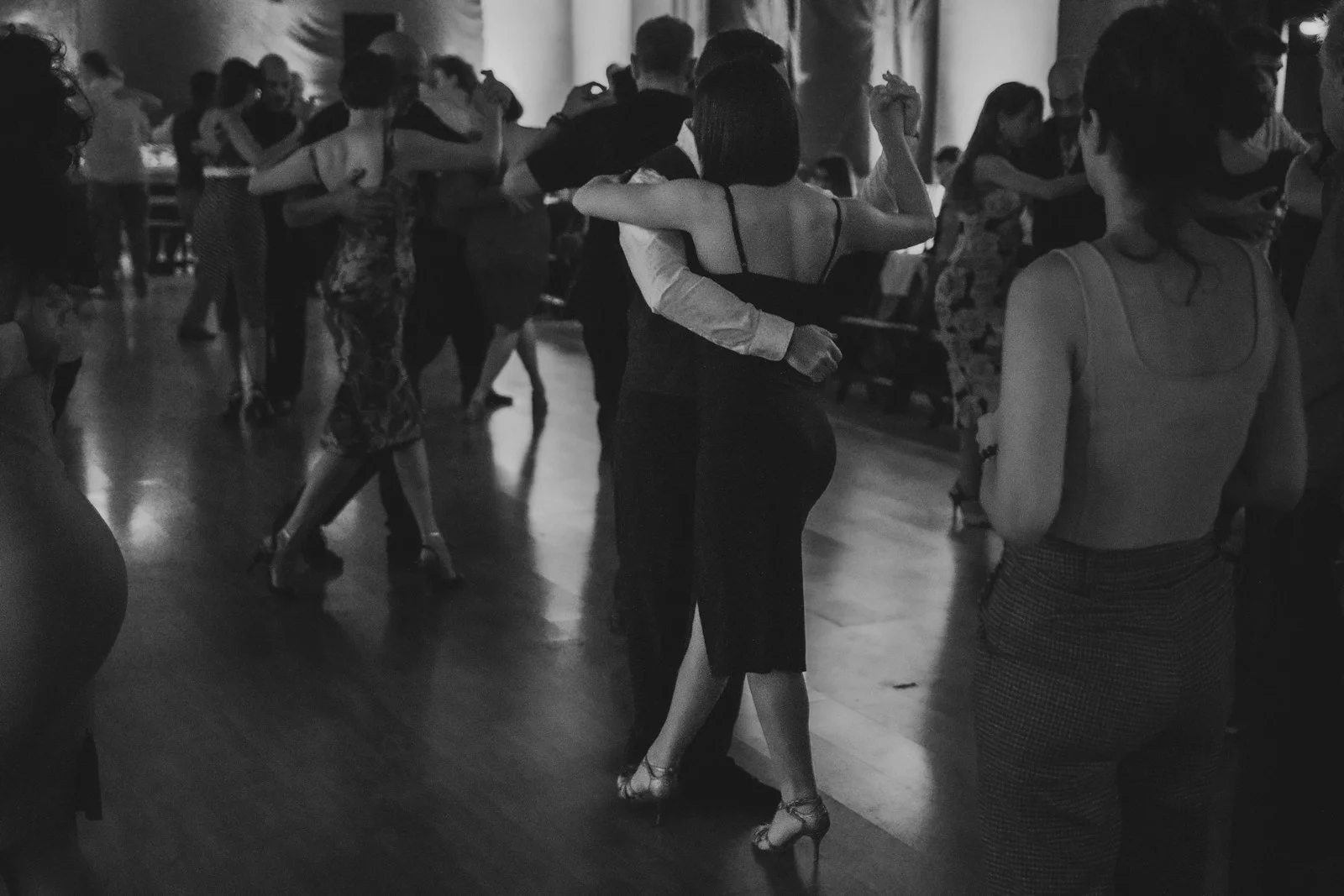 Couples dancing ballroom in a dimly lit room.