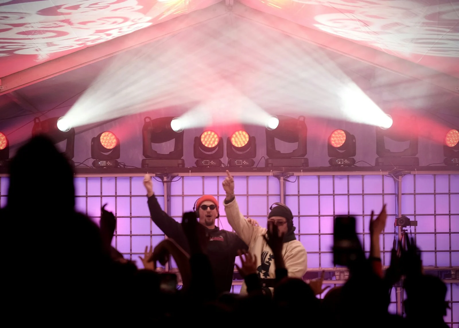 Two djs performing on stage with crowd cheering Two djs performing on stage with crowd cheering